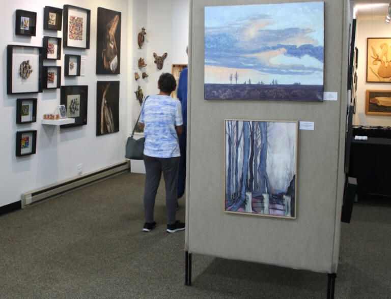Visitors peruse artwork inside Gallery 408 in downtown Camas during the new gallery's grand opening event, Friday, May 31, 2024.