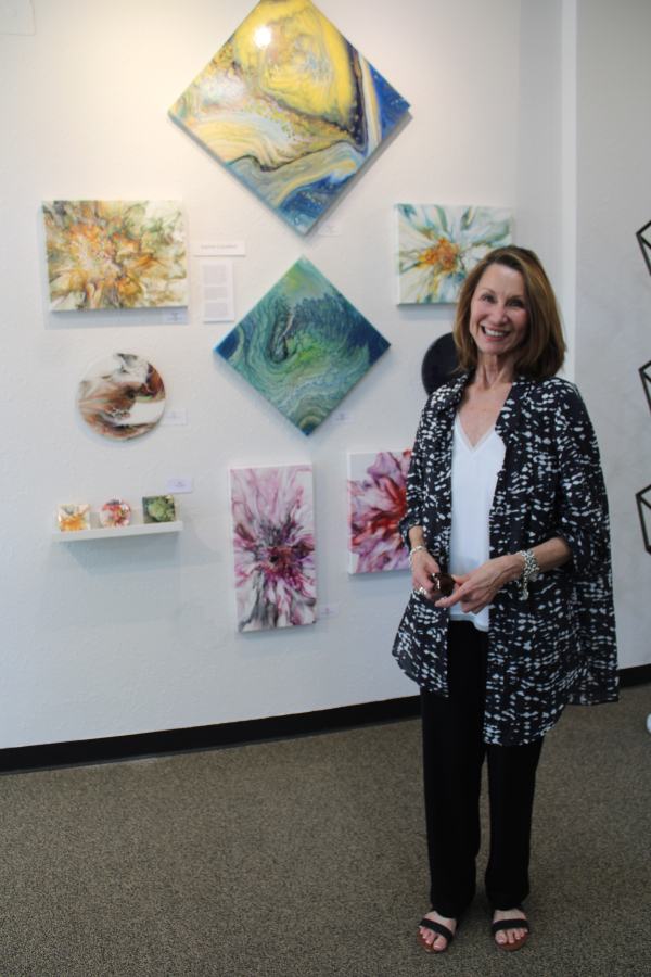 Gallery 408 owner Joanne Cavallaro stands near her artwork during the gallery's grand opening, Friday, May 31, 2024.