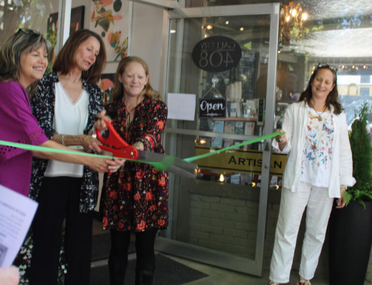 Gallery 408 owners Kim Nickens (left), Joanne Cavallaro (second from left) and Michelle Purvis (second from right) cut the ribbon outside their new gallery in downtown Camas, Friday, May 31, 2024, as Attic Gallery owner Maria Gonser (right) looks on.