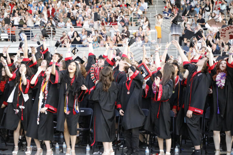 Camas High School 2024 graduates toss their mortarboard caps into the air during the school&rsquo;s commencement ceremony at Doc Harris Stadium, Friday, June 7, 2024.