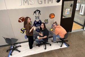 Jemtegaard Middle School students Rylee Drake (left) and Aubrey Gale (center) and art educator Teacher Dani paint a mural at the school in March 2024. (Contributed photos courtesy Washougal School District)