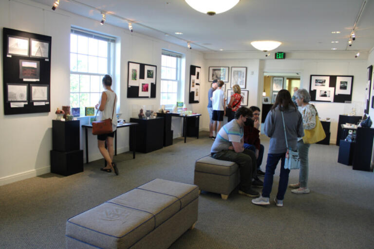 People browse Camas student artwork inside the Second Story Gallery, located on the second floor of the Camas Public Library, during the gallery's first opening following the start of the COVID-19 pandemic, on Friday, July 1, 2022.