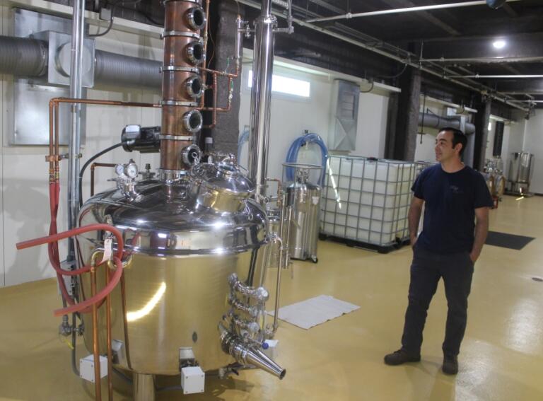 Doug Flanagan/Post-Record
Rediviva Distilling lead distiller Daniel Ruiz stands next to the distillery&rsquo;s 150-gallon pot still on July 11 in Washougal.