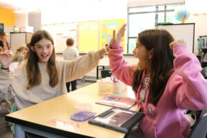 Columbia River Gorge Elementary School students Cameron Fox (left) and Evelyn Rielly high-five in an undated photo. (Contributed photo courtesy of the Washougal School District)
