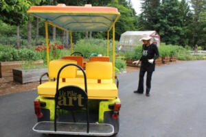 Liz Pike describes the process of turning this golf cart into a “Sunflower Mobile” to transport guests to her Fern Prairie farm, in June 2019. (Kelly Moyer/Post-Record files) 