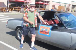 Washougal resident AJ Bogue points to a sign advertising the Camas-Washougal Community Chest’s upcoming “Cruise to the Shoug” car show on his 1980 Monte Carlo at 54-40 Brewing Company, July 18, 2024.The first-ever car show is set for Aug. 4, at 54-40. (Doug Flanagan/Post-Record)