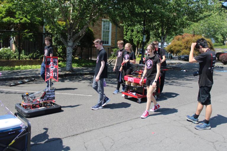 Members of the award-winning FIRST Robotics Competition Team 2471, also known as "Team Mean Machine," which includes students from Camas, Discovery, Washougal and Hockinson high schools, wait for the start of the 2024 "America the Beautiful" themed Camas Days Kids Parade near the Camas Public Library, Friday, July 26, 2024. (Kelly Moyer/Post-Record) 