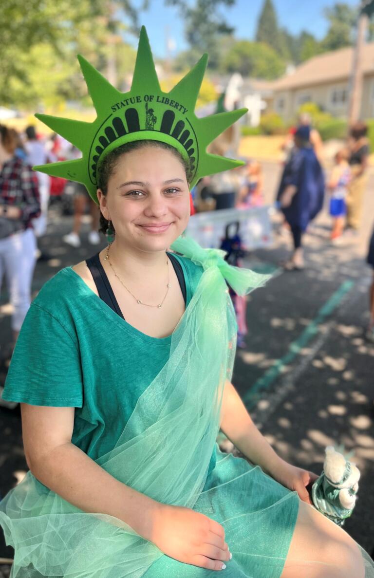 Andrea Larsen, 16, dressed as the Statue of Liberty, waits for the start of the 2024 "America the Beautiful" themed Camas Days Kids Parade near the Camas Public Library, Friday, July 26, 2024. (Kelly Moyer/Post-Record) 