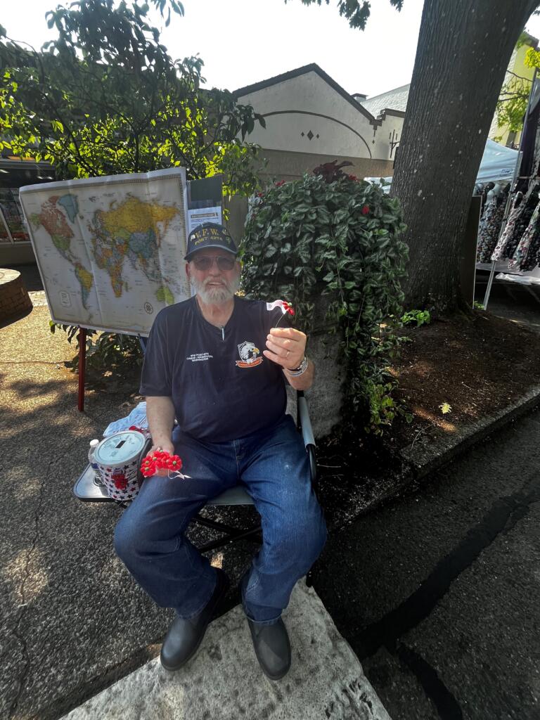 Navy veteran Waine Richards, of Fern Prairie, hands out poppies during the 2024 Camas Days festival, Friday, July 26, 2024. (Kelly Moyer/Post-Record) 