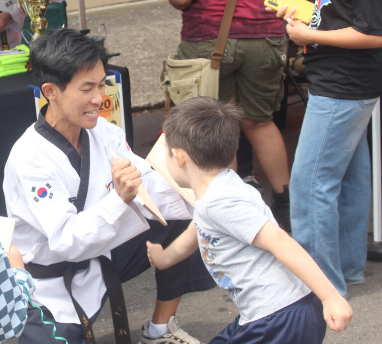 A child breaks a board, held by a World Class Martial Arts student, during the Camas Days festival on Saturday, July 27, 2024. (Doug Flanagan/Post-Record)