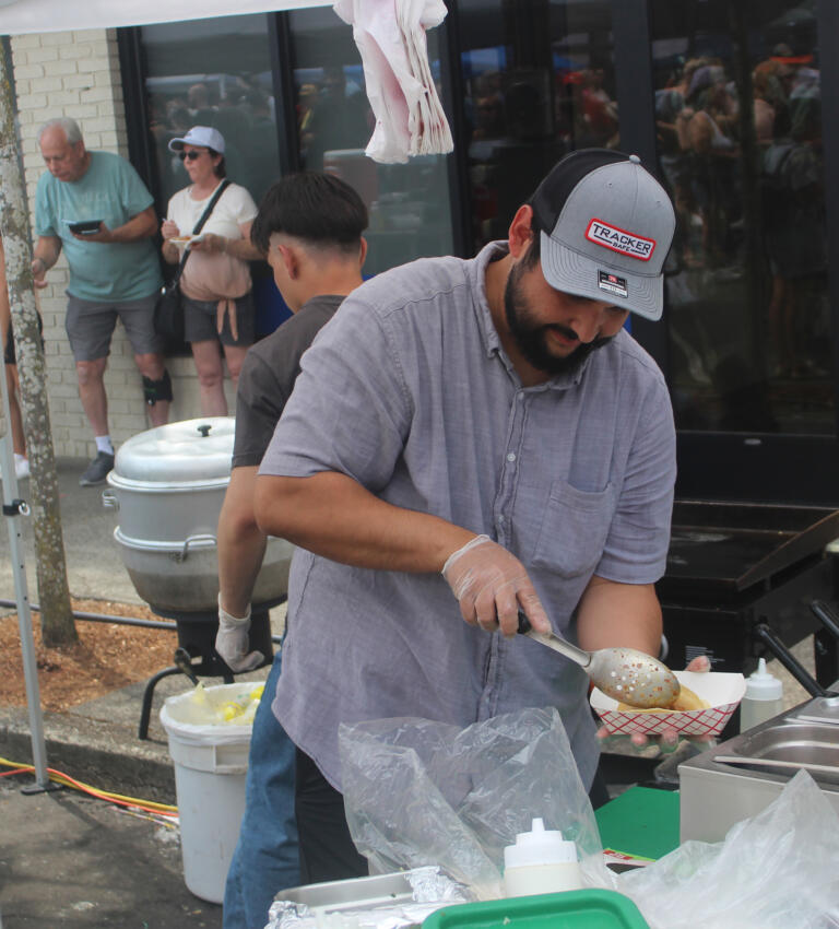 A Sabor Mexicano employee prepares a tamale for a waiting customer during the Camas Days festival on Saturday, July 27, 2024. (Doug Flanagan/Post-Record)