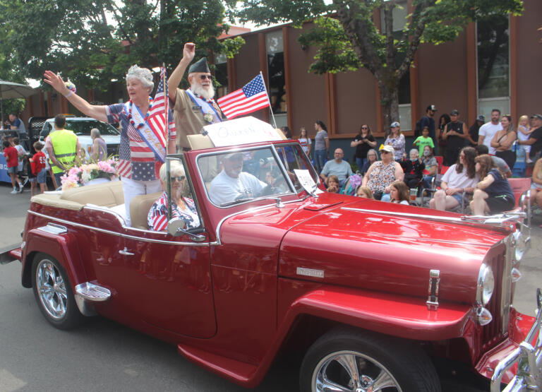 Camas Days King and Queen  Dennis and Kooky Hellan wave during the festival's grand parade on Saturday, July 27, 2024. (Doug Flanagan/Post-Record)