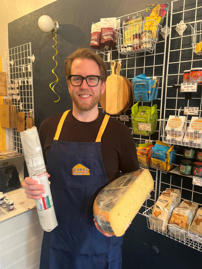 Kelly Moyer/Post-Record 
 Andy Regan shows a variety of cheeses, cured meats and cheese-board goodies available for purchase inside the Camas Cheese Co. shop Andy co-owns with his wife, Tiffany Regan, located at 231 N.E. Fourth Ave., in downtown Camas, on Monday, Aug. 12, 2024.