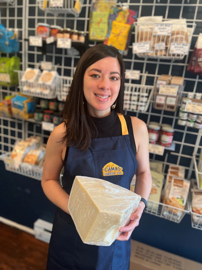 Tiffany Regan holds a hunk of Italian Parmigiano Reggiano cheese that was aged more than 30 months, inside Camas Cheese Co., Monday, Aug. 12, 2024.