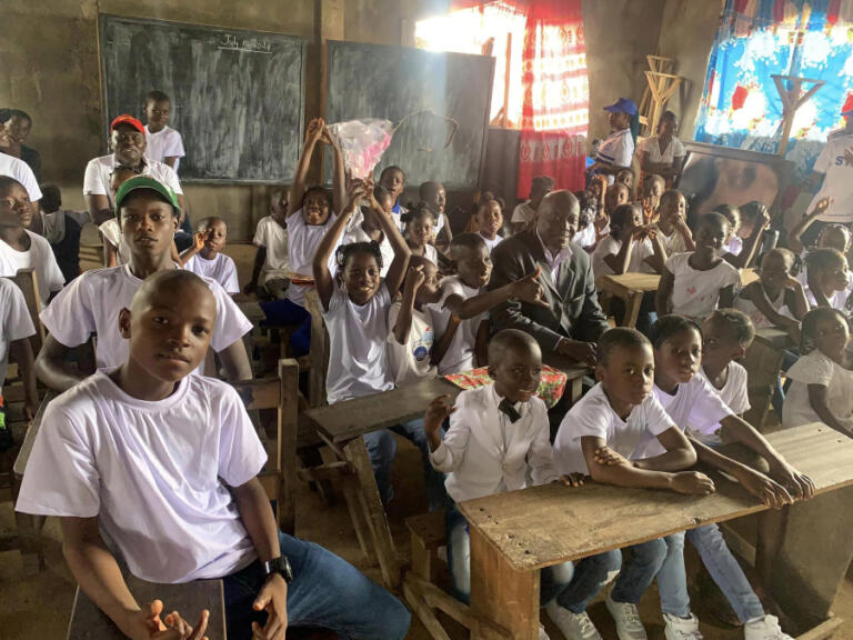 Gabanja International Volunteer Program  board chairman Felix Dordor poses for a photo with students in Liberia on July 13, 2024.