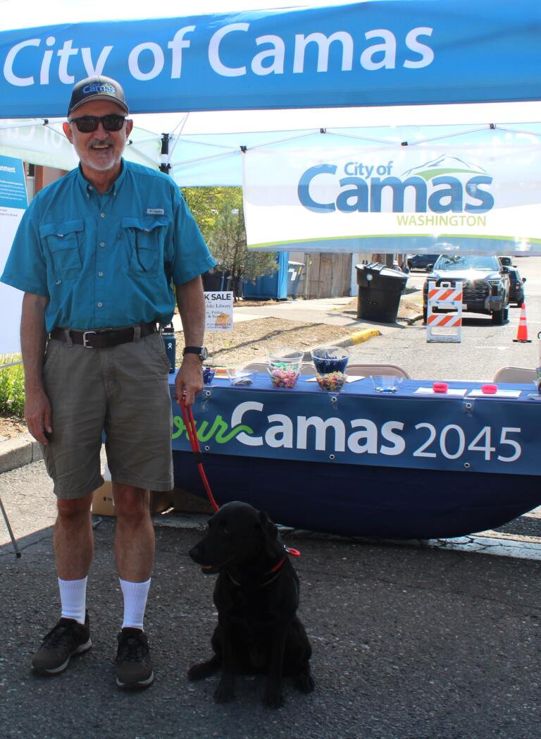 Camas City Councilman John Svilarich and his 8-year-old dog, Frankie, greet visitors to the City's booth during the first day of the 2024 Camas Days festival on Friday, July 26, 2024.