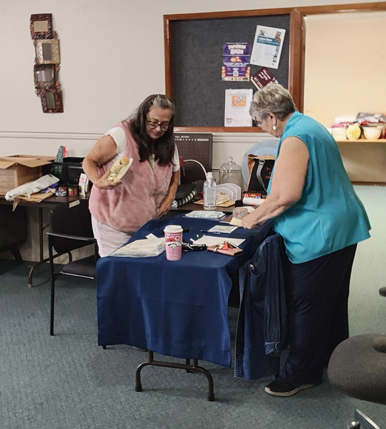 Pam Clark helps a visitor at The Outpost in Washougal, Sept.