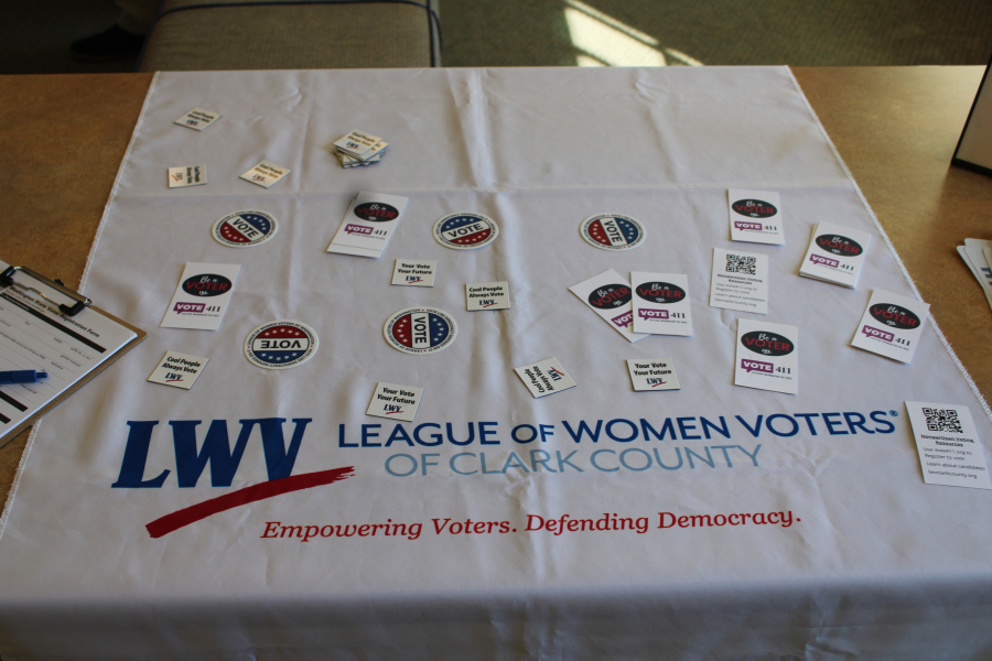 A League of Women Voters of Clark County’s table filled with stickers and information, greets visitors to the League’s candidate forum, held Saturday, Oct. 5, 2024, inside the Camas Public Library.