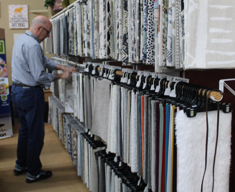 One Stop Home Furnishings owner Dave Fletcher straightens an assortment of fabric swatches inside his 70-year-old family-run business in Camas, Monday, Oct. 14, 2024.