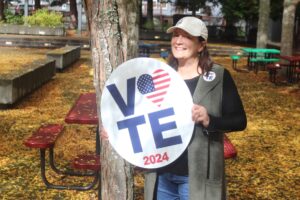 Washougal resident Lori Reed holds a yard sign she created for the American Institute of Graphic Arts’ Get Out the Vote campaign, Oct. 16, 2024. (Doug Flanagan/Post-Record)