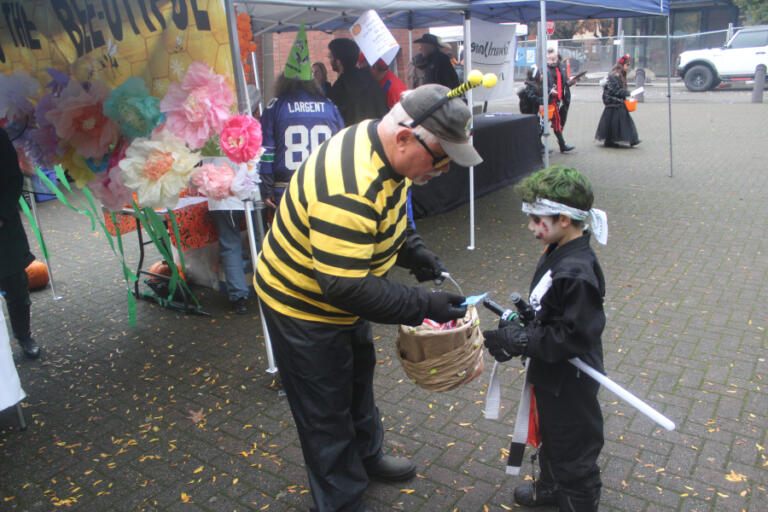 Doug Flanagan/Post-Record 
 A child receives candy during the Washougal Trick or Treat on Main Street event on Oct. 31, 2024.