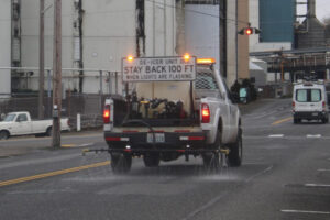 A city of Camas de-icing vehicle sprays de-icer along Northeast Sixth Avenue, near the Georgia-Pacific paper mill in downtown Camas, Friday, Jan. 12, 2024, ahead of a winter storm expected to drop 2 to 4 inches of snow on the greater Vancouver area. Camas officials are digging into the city's carbon emissions and setting goals to mitigate future climate hazards, including heavy precipitation, flooding, wildfires and extreme heat. (Kelly Moyer/Post-Record files)