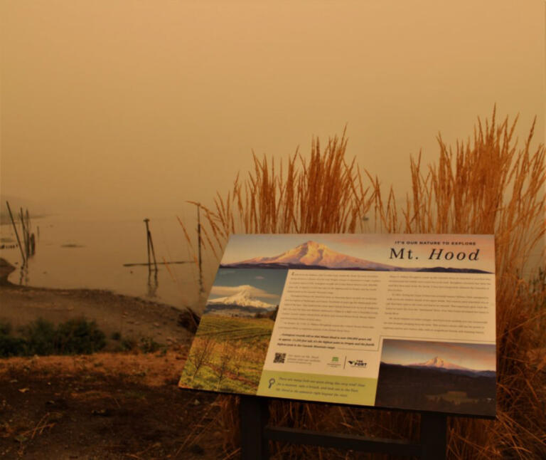 A sign shows the normal view of Mt. Hood and the Columbia River Gorge from Washougal Waterfront Park. On Friday, Sept. 11, 2020, that view was covered by a thick layer of smoke from wildfires burning in Oregon and California. The smoke has severely impacted air quality in Camas-Washougal. Camas officials in 2024-25 will tackle climate goals, including greenhouse gas emission reductions and mitigations for future climate hazards, including wildfires and wildfire smoke.