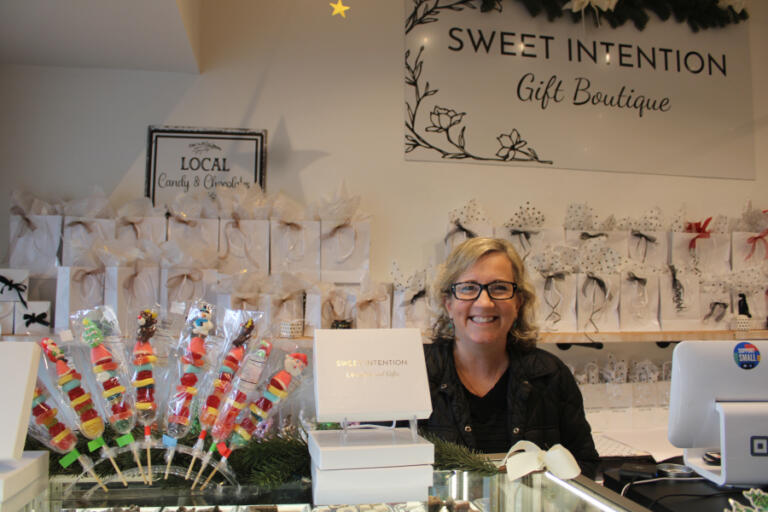 Kim Neil, a Sweet Intention worker, helps customers behind the counter of the downtown Camas retail shop on Saturday, Nov. 23, 2024. The store is offering $15 off any purchase of $100 or more during the Little Boxes and Small Business Saturday shopping events in downtown Camas the weekend after Thanksgiving.