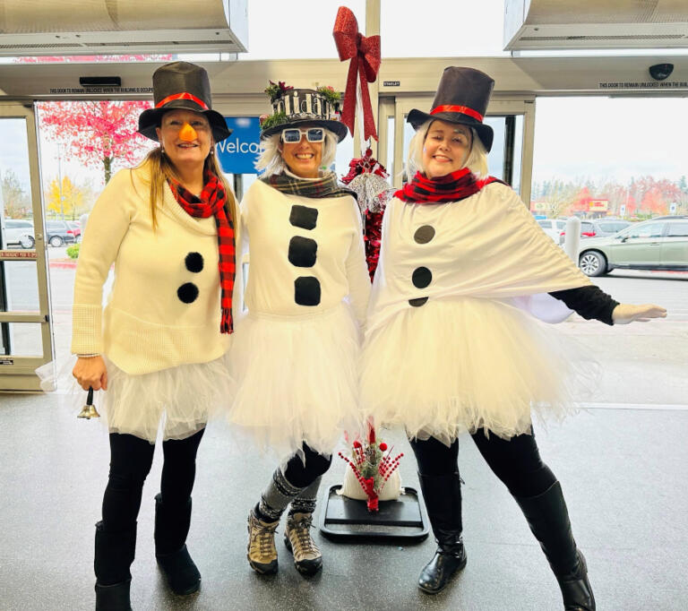 Camas-Washougal Salvation Army employees Samantha Wheeler (left) and Jessica Wheeler (right) and volunteer Tonette Sweet (center) show holiday spirit at an event held inside a Vancouver Walmart, Nov.