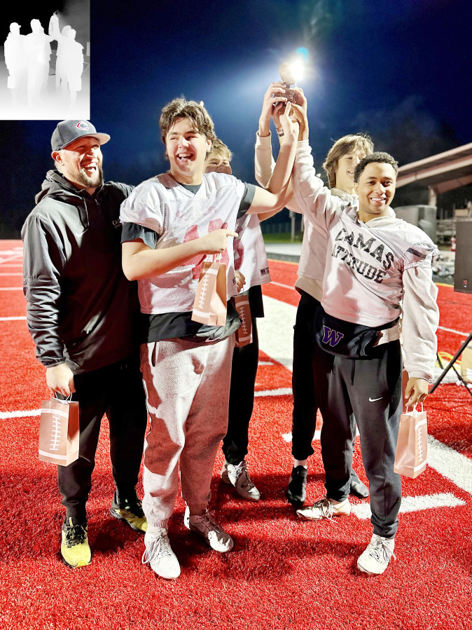 Camas High football players (left to right) Ryan Criddle, Jake Davidson, Jaxon Goode and Titan Brodie raise a trophy after winning the Camas-Washougal Salvation Army Red Kettle Kickoff, Nov. 25, 2024.