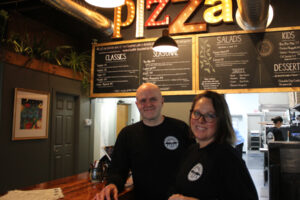 Backpacker Pizza owners Rod Harris (left) and Jami Harris stand behind the counter of their newly opened downtown Camas pizza shop on Thursday, Dec. 12, 2024. (Kelly Moyer/Post-Record)